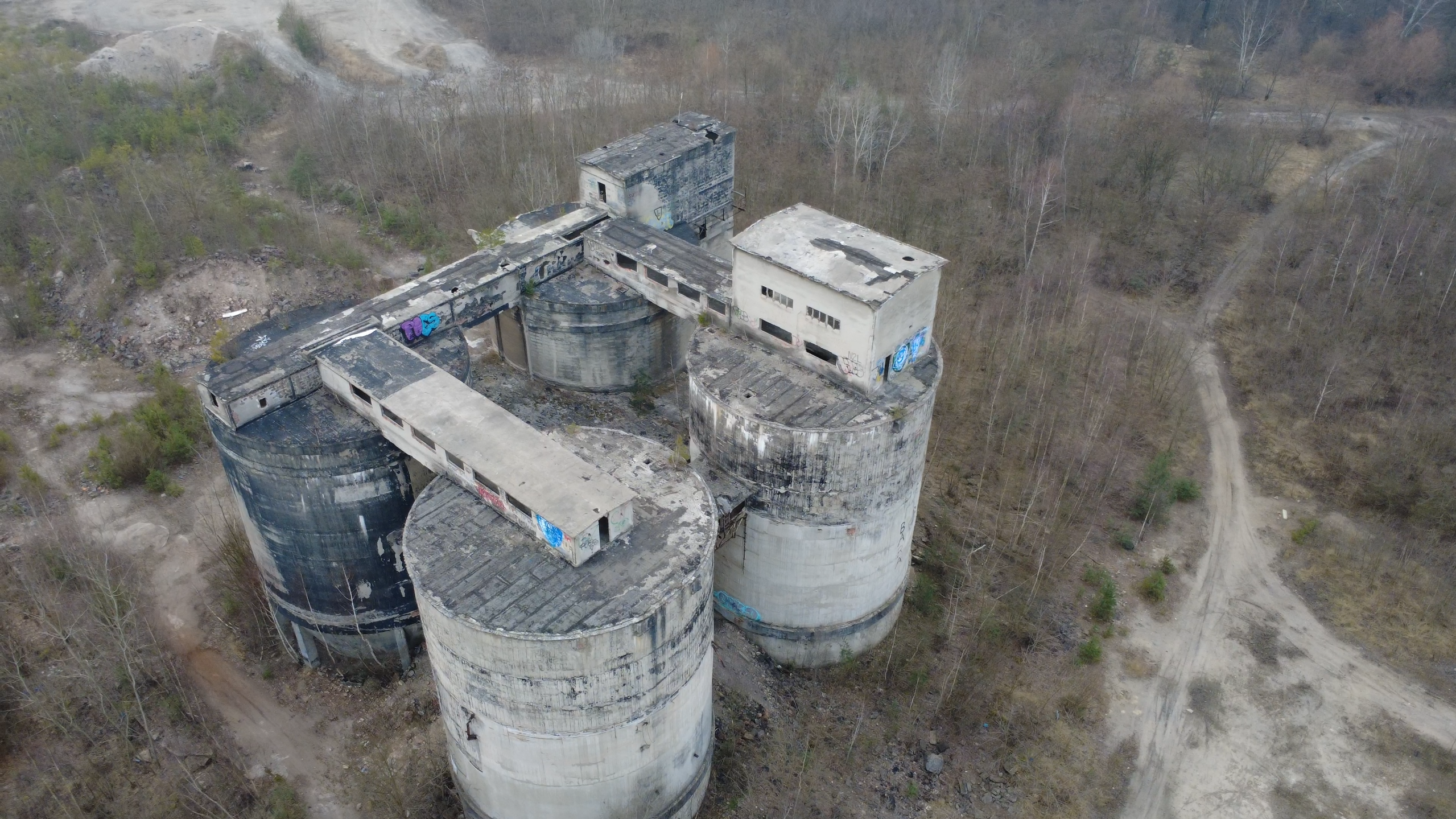 Betonowe silosy dawnej Cementowni Szczakowa zachowane na terenie przemysłowym w Pieczyskach