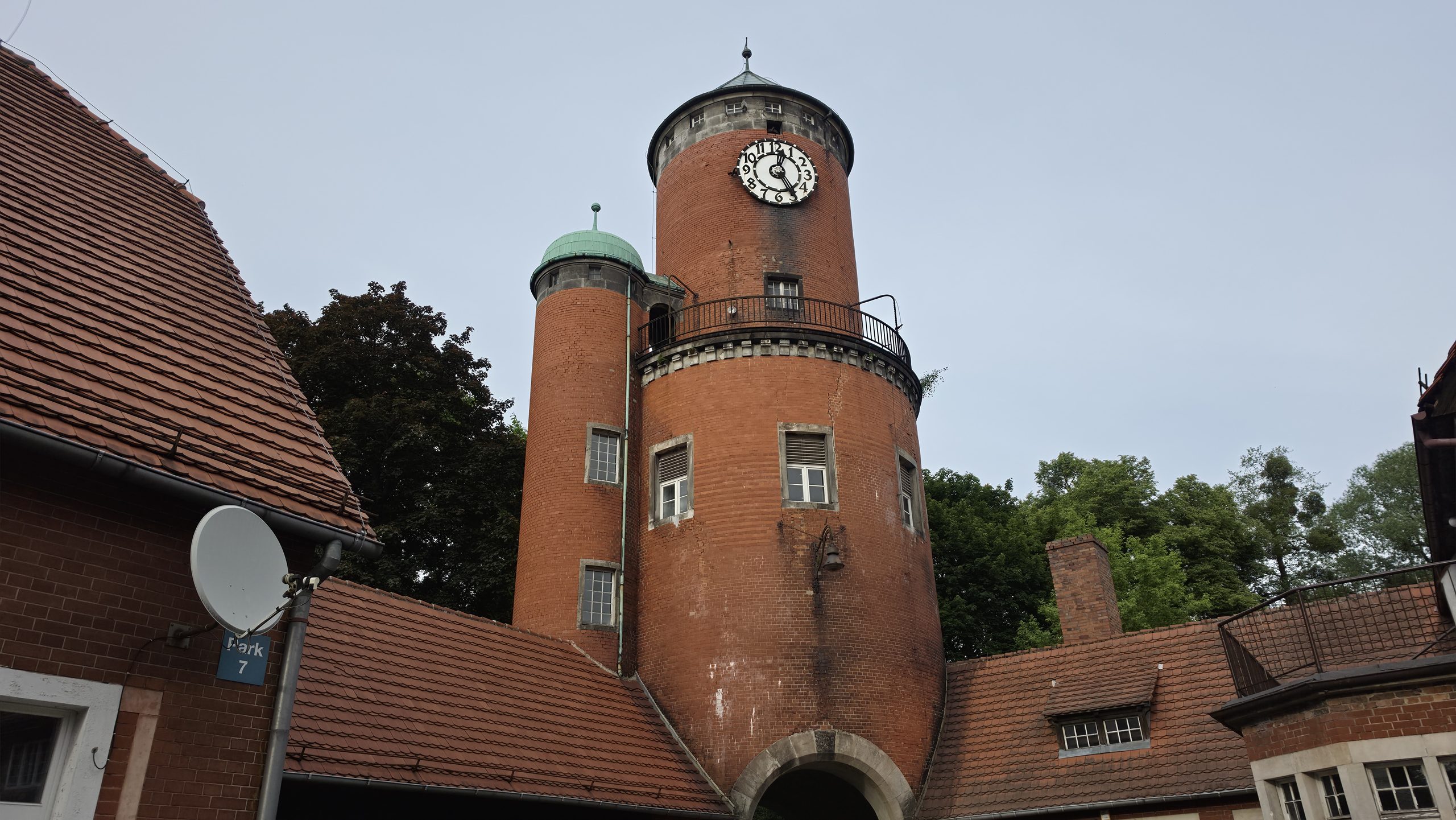 Zabudowania zespołu pałacowo-parkowego w Brynku z historyczną wieżą ciśnień i dawnym zapleczem majątku.